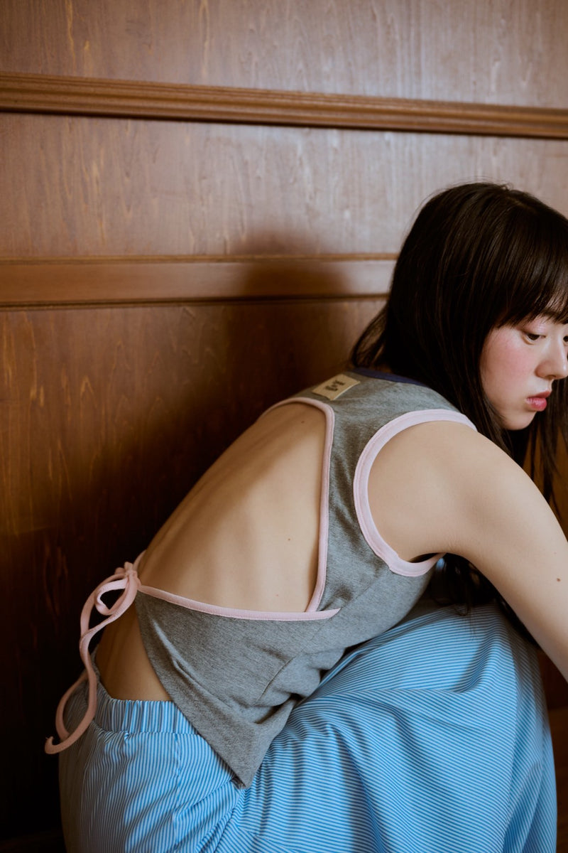 背の喪失感とリボン結びタンク